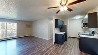 Located at 370 N Murray Blvd in Colorado Springs, CO, this two-bedroom, one-bathroom unit offers a practical and well-organized single-floor layout. The open living area greets you with durable wood-style flooring, neutral beige walls, and a textured ceiling with a ceiling fan that doubles as a light fixture. A wall-mounted A/C unit and baseboard heating provide year-round climate control. The galley-style kitchen is efficiently designed, featuring dark cabinetry with brushed nickel hardware, light countertops, a mosaic tile backsplash, stainless steel appliances including a refrigerator and electric range, and a double sink. Both bedrooms are carpeted for comfort and include ceiling fans, baseboard heating, and windows that allow natural light to filter in. Each bedroom also benefits from closet storage. The bathroom is clean and functional, equipped with a tub-shower combination with white tile surround and brushed nickel fixtures. A connecting hallway ties all rooms together efficiently. The overall aesthetic is clean and move-in ready, offering a comfortable, low-maintenance living environment in a convenient Colorado Springs location.