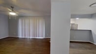 This 1-bedroom, 2-bathroom residence is thoughtfully designed to maximize functionality within a compact, single-floor layout. The open-concept living area features warm wood-style flooring and neutral gray walls, creating a bright and cohesive atmosphere. Large vertical blinds allow natural light to fill the living space, which flows seamlessly into the kitchen via a peninsula with granite countertops. The kitchen is well-equipped with white cabinetry, stainless steel appliances including a refrigerator and microwave, a black electric range, and a double stainless steel sink — all accented by granite countertops that add a polished, modern touch. The bedroom offers comfortable proportions, featuring wood-style flooring, a ceiling fan with light fixture, a window with blinds for natural light, and direct access to a dedicated closet and one of the two bathrooms. The primary bathroom includes white cabinetry with granite countertops and connects to a walk-in closet for added convenience. The second bathroom features a clean white tiled tub-shower combination. Textured ceilings are present throughout, contributing to the overall character of the space.