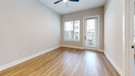 This 630-square-foot, one-bedroom, one-bathroom apartment at 2307 N Tryon St in Charlotte, NC offers an efficient and well-organized layout across a single floor. The combined kitchen and living area forms the heart of the unit, anchored by smooth hardwood-style flooring that extends throughout the space, contributing to a clean, modern aesthetic. The living area features a ceiling fan and neutral-toned walls that create a bright, airy atmosphere. A glass-paneled door opens to an outdoor area, accompanied by a large window that allows natural light to fill the room and provides views of the surrounding exterior. The primary bedroom spans 140 square feet, offering a comfortable and private retreat with dedicated closet space. The unit also includes a full bathroom and an in-unit laundry area, adding everyday convenience. The overall design emphasizes functionality and simplicity, with consistent finishes and a neutral color palette throughout. Located in the NoDa neighborhood of Charlotte, this ground-floor unit provides accessible urban living in a vibrant, well-connected area of the city.