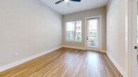 This 630-square-foot, one-bedroom, one-bathroom apartment at 2307 N Tryon St in Charlotte, NC offers an efficient and well-organized layout across a single floor. The combined kitchen and living area forms the heart of the unit, anchored by smooth hardwood-style flooring that extends throughout the space, contributing to a clean, modern aesthetic. The living area features a ceiling fan and neutral-toned walls that create a bright, airy atmosphere. A glass-paneled door opens to an outdoor area, accompanied by a large window that allows natural light to fill the room and provides views of the surrounding exterior. The primary bedroom spans 140 square feet, offering a comfortable and private retreat with dedicated closet space. The unit also includes a full bathroom and an in-unit laundry area, adding everyday convenience. The overall design emphasizes functionality and simplicity, with consistent finishes and a neutral color palette throughout. Located in the NoDa neighborhood of Charlotte, this ground-floor unit provides accessible urban living in a vibrant, well-connected area of the city.