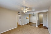 Located at 155 Mimosa Pl in Lafayette, Louisiana, this single-story 3-bedroom, 1-bathroom home offers a practical and comfortable layout. The living area features warm neutral-toned carpet, a ceiling fan with light fixture, and an open sightline into the dining area, which is accented by a hanging pendant light and wood-style flooring. A pass-through window connects the dining space to the kitchen, enhancing the open feel between rooms. The kitchen is efficiently designed with white cabinetry, marble-look countertops, a double-basin stainless steel sink, a white electric range, and a dishwasher — all set atop wood-style flooring. The primary bedroom is generously sized and includes dual open closets providing substantial storage, a ceiling fan, and its own access to the bathroom. The additional bedrooms are carpeted and each equipped with ceiling fans; one features vertical blinds over a sliding door and a distinctive white paneled accent wall. The full bathroom is clean and well-appointed, with a white vanity, tub-shower combo with tile surround, and wood-style flooring. Throughout the home, neutral wall tones and consistent finishes create a cohesive, move-in-ready atmosphere.