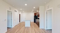 Located at 101 Madison Avenue in Athens, GA, this single-floor, 3-bedroom, 2-bathroom residence offers a well-designed open-concept layout that maximizes its efficient footprint. The kitchen serves as the centerpiece of the living area, featuring rich dark wood cabinetry, granite countertops, a full suite of black appliances including a refrigerator, range, microwave, and dishwasher, and a central island with additional counter space — ideal for both meal prep and casual dining. Recessed lighting illuminates the kitchen and adjoining living area, which flows seamlessly toward a ceiling fan and windows offering outdoor views. Light wood-style flooring runs throughout the main living spaces, providing a clean, cohesive aesthetic. The three bedrooms are bright and well-proportioned, each equipped with ceiling fans and windows that invite natural light. The spacious primary bedroom comfortably accommodates a full bedroom suite. Both bathrooms are finished consistently with granite-topped vanities featuring dark wood cabinetry, full tub-shower combos with white tile surrounds, and neutral large-format tile flooring. Two closets provide practical storage. The unit also includes two dedicated closet spaces, rounding out a thoughtfully organized and move-in ready home.
