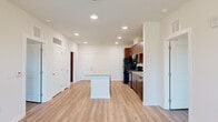 Located at 101 Madison Avenue in Athens, GA, this single-floor, 3-bedroom, 2-bathroom residence offers a well-designed open-concept layout that maximizes its efficient footprint. The kitchen serves as the centerpiece of the living area, featuring rich dark wood cabinetry, granite countertops, a full suite of black appliances including a refrigerator, range, microwave, and dishwasher, and a central island with additional counter space — ideal for both meal prep and casual dining. Recessed lighting illuminates the kitchen and adjoining living area, which flows seamlessly toward a ceiling fan and windows offering outdoor views. Light wood-style flooring runs throughout the main living spaces, providing a clean, cohesive aesthetic. The three bedrooms are bright and well-proportioned, each equipped with ceiling fans and windows that invite natural light. The spacious primary bedroom comfortably accommodates a full bedroom suite. Both bathrooms are finished consistently with granite-topped vanities featuring dark wood cabinetry, full tub-shower combos with white tile surrounds, and neutral large-format tile flooring. Two closets provide practical storage. The unit also includes two dedicated closet spaces, rounding out a thoughtfully organized and move-in ready home.