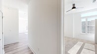 Located at 1000 Lakeside Terrace Ct in Wake Forest, NC, this well-appointed single-story home offers three bedrooms, three bathrooms, and a thoughtfully designed layout. The kitchen is a standout feature, boasting white shaker cabinetry with gold hardware, a bold navy blue center island, white subway tile backsplash, stainless steel appliances, and pendant lighting. Large windows flood the space with abundant natural light, highlighting the warm wood-look luxury vinyl flooring found throughout the main living areas. The primary bedroom is generously sized, featuring direct access to a private outdoor deck through full-length glass doors with transom windows above, offering bright, open views. Each bedroom is finished with plush carpeting and ceiling fans. The closets are equipped with wire shelving systems for organized storage. The bathrooms are tastefully appointed, with one featuring a dual-sink vanity with white cabinetry, a framed mirror, and stylish light fixtures. Another bathroom includes a tub-shower combo with large-format marble-look tile and matte black fixtures. A dedicated laundry area with full-size washer and dryer completes this clean, modern home.