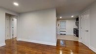 Located at 23 Wilfred St in West Orange, NJ, this single-floor unit offers a clean, modern aesthetic throughout. Rich, polished hardwood floors flow through the living areas and bedrooms, complemented by crisp white walls and recessed lighting that create a bright, welcoming atmosphere. The open layout connects the living space to the kitchen, which is outfitted with dark cabinetry, stainless steel appliances including a refrigerator, range, and microwave, and light wood-look tile flooring. A window allows natural light to filter in, adding to the functional yet stylish design. The bedrooms are well-proportioned, each featuring gleaming hardwood floors, recessed lighting, windows with outdoor views of surrounding greenery, and radiator heating units. The bathroom is tastefully renovated with a full soaking tub and shower combination, white subway tile surround, a white vanity with ample storage, brushed nickel fixtures, and wood-look tile flooring that ties the space together cohesively. Each room benefits from both a radiator heating system and wall-mounted air conditioning units, ensuring year-round comfort. The overall ambiance is clean, updated, and move-in ready.