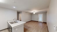 Located at 512 De Roode Street in Lexington, KY, this single-floor, 3-bedroom, 2-bathroom residence offers a practical and modern layout designed for comfortable everyday living. Light wood-style flooring runs throughout, complementing the neutral gray walls and white trim that give the space a clean, cohesive aesthetic.

The open-concept kitchen is a standout feature, showcasing dark espresso cabinetry, a light marble-style peninsula countertop with a double stainless steel sink, and black appliances including a refrigerator, range, microwave, and dishwasher. The kitchen flows seamlessly into the living room, which is brightened by a ceiling fan with a light fixture and a door providing access to a private outdoor area.

The hallways are well-organized and feature louvered storage closet doors, adding functional storage throughout. Each bedroom is finished with the same light flooring, ceiling fans or windows for natural light, and ample wall space. The primary bedroom includes a walk-in closet with wire shelving. Both bathrooms are outfitted with dark cabinetry vanities, large mirrors, and light flooring, with one bathroom featuring a tall storage tower cabinet for added convenience. The layout is efficient and thoughtfully arranged, making excellent use of the available space.