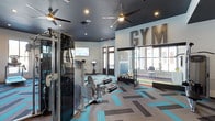 This fitness center delivers a dynamic and inviting environment for exercise enthusiasts of all levels. The space is defined by a bold, contemporary design, highlighted by a deep charcoal ceiling that creates a striking contrast against the bright white walls. Large windows along one side flood the interior with natural light, enhancing the open and energizing atmosphere. Ceiling fans are mounted throughout, ensuring comfortable airflow during even the most intense workouts.

The flooring is a standout design feature — a geometric patterned carpet in shades of teal, gray, and multicolor stripes adds a vibrant, modern energy to the space. Strength training equipment, including a cable machine and leg press apparatus, is prominently positioned for easy access. A stationary bike and wall-mounted flat-screen television are also present, supporting cardio and entertainment needs simultaneously.

A bold oversized "GYM" signage display adorns the accent wall, reinforcing the space's identity and adding an industrial-chic aesthetic. A cozy seating nook with a window view provides a space to rest or observe the surroundings. The overall ambiance is motivating, stylish, and functional — a well-thought-out fitness facility that balances form and function seamlessly.