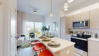 Located at 2100 SW 8th St in Miami's vibrant Little Havana neighborhood, this 2-bedroom, 2-bathroom residence offers a well-designed single-floor layout that maximizes its compact footprint. The open-concept living and kitchen area forms the heart of the unit, where tall ceilings and large sliding glass doors flood the space with natural light and provide direct access to a private balcony overlooking the surrounding cityscape.

The kitchen features light wood cabinetry extending to the ceiling, stainless steel appliances, and a white quartz island with seating — ideal for casual dining. Light wood-tone flooring runs throughout, enhancing the bright, airy atmosphere.

The primary bedroom offers a peaceful retreat with generous windows framing outdoor views, while the second bedroom is equally well-lit. Each room includes dedicated closet space. The primary bathroom features a glass-enclosed walk-in shower with marble-style tile, while the second bathroom offers a full tub-shower combination with light wood vanity cabinetry.

A hallway connects all rooms efficiently, and the overall design reflects a modern, contemporary aesthetic well-suited to Miami's dynamic urban lifestyle.