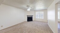 Located in Waco, TX, this single-story home offers a practical and comfortable layout across two bedrooms and two bathrooms. The living room serves as the heart of the home, featuring a classic fireplace with a sleek black surround, a ceiling fan, textured ceilings, and a large window that fills the space with natural light. Soft carpet underfoot adds warmth throughout the living areas and bedrooms.

The kitchen is designed with a pass-through counter that connects to the dining area, offering white cabinetry, light countertops, and white appliances including an electric range and refrigerator. Wood-look flooring runs through the kitchen and dining areas, providing a clean contrast to the carpeted rooms.

The spacious primary bedroom includes a ceiling fan, a bright window with natural light, and generous closet space. The second bedroom also features a ceiling fan and its own closet. Both rooms are finished with neutral tones and textured ceilings.

The bathrooms are well-appointed, with one featuring a wide vanity topped with speckled countertops, a mosaic-framed mirror, and stylish light fixtures, alongside a tub-shower combination. A connecting hallway ties all rooms together in a cohesive, functional flow throughout the home.
