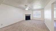 Located in Waco, TX, this single-story home offers a practical and comfortable layout across two bedrooms and two bathrooms. The living room serves as the heart of the home, featuring a classic fireplace with a sleek black surround, a ceiling fan, textured ceilings, and a large window that fills the space with natural light. Soft carpet underfoot adds warmth throughout the living areas and bedrooms.

The kitchen is designed with a pass-through counter that connects to the dining area, offering white cabinetry, light countertops, and white appliances including an electric range and refrigerator. Wood-look flooring runs through the kitchen and dining areas, providing a clean contrast to the carpeted rooms.

The spacious primary bedroom includes a ceiling fan, a bright window with natural light, and generous closet space. The second bedroom also features a ceiling fan and its own closet. Both rooms are finished with neutral tones and textured ceilings.

The bathrooms are well-appointed, with one featuring a wide vanity topped with speckled countertops, a mosaic-framed mirror, and stylish light fixtures, alongside a tub-shower combination. A connecting hallway ties all rooms together in a cohesive, functional flow throughout the home.