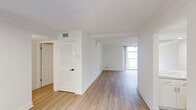 Located at 1 South Pine Island Road in Plantation, FL, this well-appointed 2-bedroom, 2-bathroom single-floor residence offers a clean, modern aesthetic throughout. Light wood-tone flooring flows consistently across the living areas and bedrooms, complementing the crisp white walls and textured ceilings that give the space a bright, airy feel.

The layout features two living areas connected by a hallway, offering flexible use of space. The main living area is highlighted by a full wall of sliding glass doors that invite natural light and provide views of lush tropical greenery on the balcony beyond. A louvered utility closet and a thermostat panel are conveniently positioned near the living space.

The kitchen is a standout feature, showcasing white high-gloss cabinetry, striking marble-style countertops and backsplash, a black undermount sink, and a full suite of stainless steel appliances including a refrigerator, range, microwave, and dishwasher.

Both bedrooms are well-sized, with the primary bedroom offering a generous footprint and a walk-in closet with built-in shelving. Each bedroom benefits from the same consistent wood flooring and neutral tones. The two bathrooms are finished in clean white tile, each featuring a tub-shower combination and marble-accented vanities, maintaining a cohesive and polished look throughout the home.