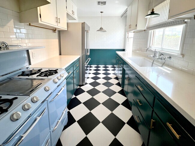 Cocina con azulejos de damero en blanco y negro, fregadero estilo granja, azulejos tipo metro y encimeras de cuarzo. - 1327 N Central Ave