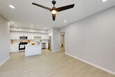 Located at 1349 Blossom Ave in Suisun City, CA, this thoughtfully designed one-bedroom, one-bathroom residence offers a clean, contemporary aesthetic throughout its single floor. The open-concept layout seamlessly connects the living room, dining area, and kitchen, creating a bright and airy atmosphere enhanced by recessed lighting and a modern ceiling fan. Light-toned luxury vinyl flooring runs throughout the main living areas, contributing to the space's fresh, modern feel.

The kitchen is a standout feature, showcasing crisp white shaker cabinetry, white quartz countertops, a central island, and a full suite of stainless steel appliances including a gas range, microwave, dishwasher, and refrigerator. Ample cabinet storage and generous counter space make this kitchen both functional and visually appealing.

The bedroom is a comfortable retreat finished with soft carpet, a ceiling fan, and a window with natural light. It connects to a dedicated closet and is conveniently positioned along a hallway that leads to the full bathroom, which features a white vanity, tub-shower combination, and clean tile finishes.

Additional highlights include a dedicated laundry area, a utility room, and a private patio — ideal for outdoor relaxation. The unit presents a cohesive, modern design with a neutral palette throughout.