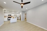 Located at 1349 Blossom Ave in Suisun City, CA, this thoughtfully designed one-bedroom, one-bathroom residence offers a clean, contemporary aesthetic throughout its single floor. The open-concept layout seamlessly connects the living room, dining area, and kitchen, creating a bright and airy atmosphere enhanced by recessed lighting and a modern ceiling fan. Light-toned luxury vinyl flooring runs throughout the main living areas, contributing to the space's fresh, modern feel.

The kitchen is a standout feature, showcasing crisp white shaker cabinetry, white quartz countertops, a central island, and a full suite of stainless steel appliances including a gas range, microwave, dishwasher, and refrigerator. Ample cabinet storage and generous counter space make this kitchen both functional and visually appealing.

The bedroom is a comfortable retreat finished with soft carpet, a ceiling fan, and a window with natural light. It connects to a dedicated closet and is conveniently positioned along a hallway that leads to the full bathroom, which features a white vanity, tub-shower combination, and clean tile finishes.

Additional highlights include a dedicated laundry area, a utility room, and a private patio — ideal for outdoor relaxation. The unit presents a cohesive, modern design with a neutral palette throughout.