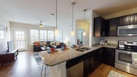 Located at 5877 N Nevada Ave in Colorado Springs, CO, this single-floor residence offers a thoughtfully designed open-concept layout that seamlessly connects the kitchen and living areas. The kitchen is a standout feature, equipped with rich dark cabinetry, granite countertops, stainless steel appliances including a range, microwave, and refrigerator, and a large peninsula with pendant lighting — ideal for both cooking and casual dining. Hardwood flooring flows throughout the main living areas, adding warmth and continuity to the space. The living room is bright and inviting, benefiting from large windows and a glass door that floods the room with natural light while providing access to an outdoor balcony. A ceiling fan adds both style and functionality to this comfortable gathering space. Multiple bedrooms offer plush carpeting, generous closet space, and ample natural light. The bathrooms are well-appointed with dark vanity cabinetry, granite countertops, tile flooring, and full tub-shower combinations. An in-unit laundry area adds everyday convenience. Overall, this residence presents a clean, modern aesthetic with practical, well-considered design elements throughout.