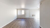 Located at 1390 Creekside Dr in Walnut Creek, California, this single-floor apartment offers a well-designed layout with consistent wood-style flooring throughout. The open living area provides generous space, featuring neutral warm-toned walls, white trim, and a wall-mounted HVAC unit. Natural light filters in through windows dressed with vertical blinds, lending the living space a bright and airy feel. A structural column accents the living area, adding architectural interest while a built-in heater is also present.

The kitchen is a standout feature, outfitted with crisp white shaker-style cabinetry, granite countertops, a stainless steel sink, dishwasher, and electric range with an overhead ventilation hood — offering both style and functionality.

The bedrooms are comfortably sized with the same wood-style flooring, neutral walls, and ample natural light. One bedroom includes a ceiling fan with light fixture, a window with garden views, and a sliding closet. Additional rooms offer clean, versatile spaces adaptable to various uses.

The bathroom is well-appointed with a full tub-shower combo, white cabinetry, granite countertop vanity, and a lighted mirror, maintaining the updated aesthetic found throughout the residence.