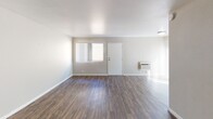 Located at 1390 Creekside Dr in Walnut Creek, California, this single-floor apartment offers a well-designed layout with consistent wood-style flooring throughout. The open living area provides generous space, featuring neutral warm-toned walls, white trim, and a wall-mounted HVAC unit. Natural light filters in through windows dressed with vertical blinds, lending the living space a bright and airy feel. A structural column accents the living area, adding architectural interest while a built-in heater is also present.

The kitchen is a standout feature, outfitted with crisp white shaker-style cabinetry, granite countertops, a stainless steel sink, dishwasher, and electric range with an overhead ventilation hood — offering both style and functionality.

The bedrooms are comfortably sized with the same wood-style flooring, neutral walls, and ample natural light. One bedroom includes a ceiling fan with light fixture, a window with garden views, and a sliding closet. Additional rooms offer clean, versatile spaces adaptable to various uses.

The bathroom is well-appointed with a full tub-shower combo, white cabinetry, granite countertop vanity, and a lighted mirror, maintaining the updated aesthetic found throughout the residence.