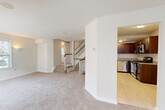 Located at 140 Hackensack St in East Rutherford, NJ, this multi-level townhome offers 2 bedrooms and 3 bathrooms across three thoughtfully laid-out floors. The classic brick exterior with white-railed balcony gives the home strong curb appeal, complemented by lush landscaping and a white perimeter fence.

The main living level provides a generous, open carpeted living area filled with natural light from multiple windows, with staircases featuring warm wood handrails and white balusters connecting each floor seamlessly. The kitchen is well-appointed with rich dark cabinetry, granite countertops, tile flooring, and a full suite of stainless steel appliances including a gas range, dishwasher, microwave, and refrigerator.

The upper level hosts the spacious primary bedroom, accented by crown molding, dual closets, and a private en-suite bathroom with tile flooring and vanity. A second well-sized bedroom offers bright natural light through large windows and plush carpeting. The bathrooms throughout are finished with clean white vanities, tile floors, and tub-shower combinations. Additional conveniences include a dedicated laundry room, utility room, and five closets providing excellent storage. A private balcony offers pleasant outdoor access, rounding out this functional and well-designed townhome.