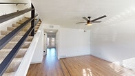 This two-story home in Germantown, Tennessee, offers a well-designed layout spread evenly across two floors. The main level features an open living room finished with light hardwood-style flooring, a ceiling fan with integrated lighting, and a textured ceiling. Natural light filters in through the front entry, where double glass doors lead into a connecting hallway. A built-in bench with open storage cubbies and wall-mounted hooks nestled beneath the staircase provides a practical entryway nook.

The kitchen is appointed with white shaker cabinetry, a marble-look quartz peninsula with an undermount sink, a matching tile backsplash, stainless steel appliances, and recessed lighting. A half bathroom is conveniently located on this floor.

Upstairs, both bedrooms are carpeted and equipped with ceiling fans. The generously sized primary bedroom features a sliding barn door leading to a walk-in closet. The second bedroom offers ample space and a standard closet. Two full bathrooms serve the upper level, each finished with white quartz countertops, undermount sinks, black matte hardware, and marble-style tile surrounds, delivering a cohesive, contemporary aesthetic throughout.