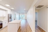 Located at 60 Cortona Point Dr in Goleta, CA, this well-appointed 2-bedroom, 3-bathroom residence offers a thoughtfully designed single-floor layout with a clean, modern aesthetic throughout. The open-concept kitchen and living area serves as the heart of the home, featuring white shaker cabinetry, stainless steel appliances including a gas range, microwave, and French door refrigerator, a white quartz countertop island, and recessed lighting. Light wood-look flooring flows seamlessly throughout the entire space, lending warmth and visual continuity. Large sliding glass doors at the end of the living area invite abundant natural light and provide views of the surrounding exterior. The primary bedroom is a well-sized retreat with recessed lighting and easy access to one of the three bathrooms. The second bedroom mirrors the same bright, neutral palette with a window that brings in natural light. Both closets are outfitted with built-in shelving and hanging rods for optimized storage. The bathrooms are finished with white vanity cabinetry, quartz countertops, and backlit mirrors, maintaining the home's cohesive, contemporary style. Two hallways and a dedicated entrance area contribute to a practical and efficient floor plan. The overall ambiance is clean, bright, and move-in ready.