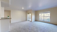 This thoughtfully designed 1-bedroom, 1-bathroom residence offers a comfortable and functional layout across a single floor. The living room is a standout feature, highlighted by crown molding, soft carpeting, and an abundance of natural light streaming through a large picture window and sliding glass doors that open onto a private balcony with outdoor views of surrounding greenery.

The kitchen is well-equipped with rich dark wood cabinetry, granite-style countertops, stainless steel appliances including a range and over-the-range microwave, and durable wood-look flooring — providing both style and practicality.

The bedroom is a comfortable retreat, carpeted throughout and fitted with a track lighting fixture. It connects conveniently to a dedicated closet featuring wire shelving for organized storage.

The bathroom is clean and bright, featuring a full tub-shower combination with a decorative tile accent border, a dark wood vanity with a wide countertop, a large mirror, and wood-look flooring that ties the space together cohesively.

A separate laundry room with washer/dryer hookups and additional shelving adds everyday convenience. A hallway connects the rooms efficiently, completing this well-organized and move-in ready home.