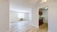Located at 6871 Ames Rd in Parma, Ohio, this single-floor, 2-bedroom unit offers a practical and well-organized layout with a clean, modern aesthetic throughout. Light wood-style flooring runs consistently across all rooms, lending a bright and cohesive feel to the entire space.

The living room is open and airy, featuring a large window that allows natural light to fill the room, alongside a wall-mounted HVAC unit and baseboard heating. A ceiling fan is positioned near the entryway, adding to the functional design. The space flows naturally toward the kitchen, which is accessible via an open pass-through and features rich, dark cherry wood cabinetry, granite-style countertops, a stainless steel sink, ample upper and lower cabinet storage, and white appliances including a range.

The primary bedroom is generously sized, offering a window with blinds for natural light and privacy, as well as baseboard heating and a wall HVAC unit. The second bedroom is similarly finished with the same light flooring, a window overlooking greenery, and baseboard heating. A dedicated closet provides additional storage within the unit.

Throughout, the walls are painted a crisp white and neutral tones, creating a clean and move-in-ready environment. The consistent finishes across all rooms give this unit a unified, well-maintained appearance.