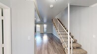 Located at 2001 S Haster St in Anaheim, California, this two-story residence offers a clean, modern aesthetic throughout its well-maintained interior. The main level welcomes you with durable wood-look flooring that flows seamlessly through the open living areas, complemented by soft gray walls and crisp white trim. A carpeted staircase with a white railing connects the two floors, adding a classic touch to the layout. The living area is bright and open, with sliding glass doors and vertical blinds that lead to a private outdoor patio, allowing natural light to fill the space. The kitchen features white cabinetry with ample storage, granite-patterned countertops, and a white appliance suite, creating a functional and cohesive cooking environment. The upper level hosts well-proportioned bedrooms, including one with a mirrored sliding-door closet and an electrical panel for added utility. Additional bedrooms are bright, with windows fitted with vertical blinds offering outdoor views. The bathrooms are finished with granite-topped vanities, mirrors, and wood-look flooring that maintains consistency with the rest of the home. Crown molding accents select areas, adding architectural detail throughout. The overall ambiance is light, neutral, and move-in ready.