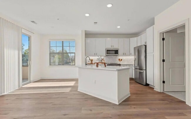 Bright Apartment Layout Featuring White Kitchen and Wood Floors - The Maggie