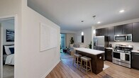 Located at 2550 Waterview Dr in Northbrook, IL, this one-bedroom, one-bathroom residence offers a thoughtfully designed layout across a single floor. The open-concept kitchen is a standout feature, showcasing rich dark cabinetry, stainless steel appliances including a gas range, microwave, and French door refrigerator, along with a crisp white quartz island with bar seating and elegant pendant lighting overhead. Wood-look flooring flows throughout the main living areas, adding warmth and cohesion to the space. The living room is bright and welcoming, highlighted by large sliding glass doors that open to an outdoor patio area, filling the room with natural light and providing a seamless connection to the outdoors. The bedroom features plush carpeting, a window for natural light, and a built-in closet with organized shelving, offering ample storage. The bathroom is finished with dark cabinetry, a white quartz vanity, wood-look flooring, and a full tub-shower combination. Clean white walls and modern finishes throughout lend the space a contemporary, move-in-ready feel. A dedicated closet provides additional storage, completing this efficiently designed residence.