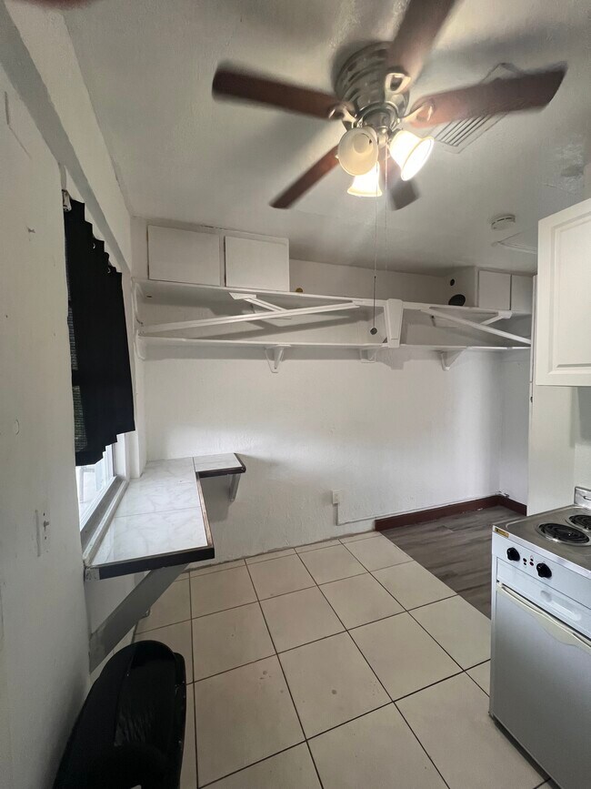 Kitchen bar with overhead storage. Window facing the driveway - 2375 NE 9th St