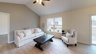 Located on Foster Drive in Webster, NY, this well-appointed single-floor home offers a thoughtfully designed open-concept layout that blends comfort with modern finishes. The living room is a standout, featuring striking vaulted ceilings and light hardwood-style flooring that create an airy, spacious atmosphere. Natural light flows freely throughout the home via generously sized windows in every room.

The kitchen is a functional centerpiece, showcasing rich dark wood cabinetry, a central island with a clean white countertop, stainless steel appliances including a refrigerator, range, microwave, and dishwasher, and a window-side sink. Adjacent to the kitchen, the dining area offers a chandelier overhead and a sliding glass door that opens to the outdoors.

The bedrooms feature plush carpeting and ceiling fans, with ample natural light from large windows. A dedicated study or flex room offers carpet flooring and a bright window, ideal for a home office. Storage is well-considered, with a spacious walk-in closet equipped with wire shelving. The bathrooms are finished with dark tile flooring and dark wood vanities — one featuring a tub/shower combo and another offering a walk-in shower with a curtain enclosure. This home combines practical design with inviting details throughout.