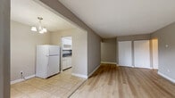 Located at 14966 108 Ave in Surrey, BC, this single-floor, 2-bedroom, 1-bathroom unit offers a practical and well-organized layout. The combined living and dining area is anchored by light wood laminate flooring and features a sliding glass door that opens onto a private patio, bringing in natural light and views of surrounding greenery. Baseboard heating runs throughout the main living spaces, ensuring consistent warmth. The kitchen is positioned adjacent to the living area and features white cabinetry, a tile backsplash, a white appliance package including a refrigerator and electric stove, and tile flooring. A dedicated entrance and hallway connect the main living spaces to the bedrooms and bathroom. Both bedrooms are finished with the same light wood flooring, offer natural light through windows, and are well-served by the unit's six closets, providing generous storage. The primary bedroom is a comfortable size with dual closet access. The bathroom is finished with tile flooring and surround, a white vanity with granite-style countertop, and a large mirror. The overall palette of warm neutral tones and clean white trim creates a cohesive and functional living environment.
