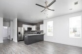 Located at 418 30th Ave E in Tuscaloosa, Alabama, this two-story home offers a contemporary design with clean lines and modern finishes throughout. Wood-look flooring flows seamlessly across the living areas, complementing the bright, neutral color palette.

The kitchen is a standout feature, showcasing granite countertops, a two-tone cabinet design with dark lower cabinets and white upper cabinets, stainless steel appliances including a refrigerator and range, a stainless steel wall-mounted range hood, and a peninsula that provides additional counter space and opens to the adjacent dining area. Multiple windows fill the dining space with natural light.

Living areas are well-lit and open, with recessed lighting, ceiling fans, and access to the outdoors via glass-panel French doors and a private exterior door. The bright, airy rooms benefit from strategically placed windows that invite natural light while maintaining privacy.

The bathrooms are finished with granite-topped vanities, dark wood cabinetry, and tub-shower combinations, maintaining the same quality aesthetic found throughout the home. A dedicated laundry area accommodates a full-size washer and dryer. The layout is practical and efficient, with well-proportioned rooms connected by a clean hallway, making this home a well-appointed residence in Tuscaloosa.