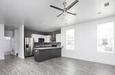 Located at 418 30th Ave E in Tuscaloosa, Alabama, this two-story home offers a contemporary design with clean lines and modern finishes throughout. Wood-look flooring flows seamlessly across the living areas, complementing the bright, neutral color palette.

The kitchen is a standout feature, showcasing granite countertops, a two-tone cabinet design with dark lower cabinets and white upper cabinets, stainless steel appliances including a refrigerator and range, a stainless steel wall-mounted range hood, and a peninsula that provides additional counter space and opens to the adjacent dining area. Multiple windows fill the dining space with natural light.

Living areas are well-lit and open, with recessed lighting, ceiling fans, and access to the outdoors via glass-panel French doors and a private exterior door. The bright, airy rooms benefit from strategically placed windows that invite natural light while maintaining privacy.

The bathrooms are finished with granite-topped vanities, dark wood cabinetry, and tub-shower combinations, maintaining the same quality aesthetic found throughout the home. A dedicated laundry area accommodates a full-size washer and dryer. The layout is practical and efficient, with well-proportioned rooms connected by a clean hallway, making this home a well-appointed residence in Tuscaloosa.