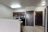 Located at 701 15th St SE in Orange City, Iowa, this one-bedroom, one-bathroom residence offers a thoughtfully designed single-floor layout. The open-concept living, dining, and kitchen area forms the heart of the home, with durable wood-look flooring in the kitchen transitioning to plush carpet in the living and dining spaces. The kitchen is outfitted with dark espresso cabinetry, a marble-look countertop peninsula with a built-in sink, and black appliances including a refrigerator, range, and over-the-range microwave. A sliding glass door leads from the living area to a private balcony, filling the space with natural light and offering neighborhood views. Baseboard heating runs along the exterior walls, providing efficient warmth throughout. The bedroom is a comfortable retreat featuring soft carpet, a large window with outdoor views, and a set of double doors leading to a generous closet. An additional closet provides extra storage elsewhere in the unit. The full bathroom features wood-look flooring, a full tub-shower combo, a dark vanity, and clean, neutral finishes. A dedicated laundry area rounds out this well-appointed residence, offering convenience and functionality throughout.