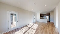 Located at 4550 Falmer Dr in Bethlehem, PA, this well-appointed single-floor home offers two bedrooms and two full bathrooms within a thoughtfully designed layout. Light-toned hardwood-style flooring runs throughout, tying together a clean, modern aesthetic enhanced by neutral walls and recessed lighting.

The open living area is bright and welcoming, with large windows and a glass-panel door that invite abundant natural light and provide views of the outdoors. The kitchen is efficiently laid out and well-equipped, featuring dark gray shaker-style cabinetry, white countertops, stainless steel appliances including a refrigerator, range, microwave, and dishwasher, along with pendant lighting over the counter peninsula.

A central hallway with panel-style doors and matte black hardware connects the bedrooms and bathrooms. The spacious primary bedroom includes multiple windows, a ceiling fan, and access to a closet and en-suite bathroom. The second bedroom also features a ceiling fan and large windows with outdoor views. One bathroom includes a full soaking tub-shower combo, while the second offers a walk-in shower, both finished with brushed fixtures and light flooring.