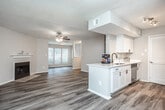 Located at 820 Canton Rd NE in Marietta, Georgia, this single-floor unit offers a well-designed layout with a blend of comfort and modern updates throughout. The open-concept living and dining area is a welcoming centerpiece, featuring durable wood-style plank flooring, a ceiling fan, a textured ceiling, and a classic fireplace that anchors the room. Natural light filters in through blinds-covered windows, creating a bright and airy atmosphere. A half-wall peninsula connects the living area to the galley-style kitchen, which is appointed with crisp white shaker cabinetry, white quartz countertops, a deep undermount sink with a matte black faucet, and stainless steel appliances including a refrigerator and range. The kitchen also provides direct access to an in-unit laundry area with louvered closet doors. Two bedrooms are finished with plush carpeting, ceiling fans, and windows offering views of the surrounding greenery, each providing a calm and comfortable retreat. The two bathrooms are clean and contemporary, featuring white vanities with expansive mirrors, updated hardware, and shower-tub combinations. The overall design is neutral and move-in ready, with consistent finishes creating a cohesive look throughout the space.