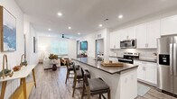 Located at 1775 Ashlar Dr in Fort Collins, CO, this well-appointed two-bedroom, two-bathroom residence offers a thoughtfully designed single-floor layout with modern finishes throughout. The open-concept kitchen and living area serves as the heart of the home, where crisp white shaker cabinets, a subway tile backsplash, dark quartz countertops, and a full suite of stainless steel appliances — including a French door refrigerator, electric range, and built-in microwave — create a polished, functional space. A peninsula with bar seating provides both additional prep space and a casual dining option. Wood-look luxury vinyl plank flooring extends through the main living areas, complementing the clean, contemporary aesthetic. The living room is bright and inviting, with large windows allowing generous natural light and a ceiling fan overhead. The primary bedroom features plush carpeting, a ceiling fan, a walk-in closet with built-in shelving and hanging rods, and an en-suite bathroom complete with a walk-in shower, white cabinetry, and quartz countertops. The second bedroom is equally well-sized and comfortable, served by a second full bathroom featuring a shower-tub combination. Recessed lighting throughout and a neutral color palette give the entire space a clean, modern ambiance.