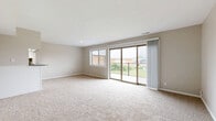 Located at 4113 NE Davidson Rd in Kansas City, MO, this single-floor, 2-bedroom, 2-bathroom home offers a practical and comfortable layout. The spacious living room is highlighted by plush carpeting, a large window, and sliding glass doors that open to a private balcony with an iron railing, allowing abundant natural light and outdoor views. A bold blue front door adds a distinctive touch to the entryway. The kitchen features white cabinetry, dark countertops, tile backsplash, wood-look flooring, and white appliances including a refrigerator and electric range. Both bedrooms are carpeted and finished in neutral tones, each equipped with a closet — the primary bedroom includes a walk-in closet, while the secondary bedroom features a bifold-door closet. The bathrooms include wood-look flooring and a tub-shower combination with white subway tile surround. Throughout the home, consistent neutral wall tones, clean white trim, and a mix of carpet and wood-look flooring create a cohesive and move-in-ready aesthetic. A connecting hallway ties the layout together efficiently, making this a well-organized and functional single-level home.