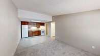 Located at 3863 Memorial Drive in Decatur, GA, this single-floor, one-bedroom, one-bathroom unit offers a practical and functional layout. The open-concept living area flows seamlessly into the kitchen, creating a connected and efficient use of space. The living room features neutral-toned carpet, a textured ceiling, and a wall-unit HVAC system beneath a window that brings in natural light. The front entry door opens directly into this space, providing easy access.

The kitchen is defined by rich, warm-toned wood cabinetry, a white refrigerator, white range, and a skylight-style overhead light fixture that brightens the cooking area. Light wood-style flooring runs throughout the kitchen, transitioning to carpet in the living and bedroom areas.

The bedroom is a comfortable size, featuring carpet flooring, a ceiling fan with integrated lighting, and a window that allows natural light and outdoor views. A hallway connects the main living areas to the bedroom, bathroom, and utility room.

The bathroom includes a white vanity, toilet, and a full tub-shower combination with a curtain rod. Light wood-style flooring carries through the bathroom, complementing the neutral wall tones. The utility room houses a water heater, completing the unit's practical amenities.