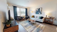Located at 6847 Stewart Rd in Cincinnati, Ohio, this single-floor residence offers a thoughtfully designed open-concept layout with contemporary finishes and a warm, inviting ambiance. The living room serves as the heart of the home, featuring durable wood-style flooring, large windows dressed with floor-to-ceiling curtains that flood the space with natural light, and views of the surrounding neighborhood. The space accommodates comfortable seating arrangements and stylish décor elements that contribute to a modern aesthetic.

The kitchen is a standout feature, showcasing crisp white upper cabinetry contrasted by dark lower cabinets, granite-style countertops, a classic subway tile backsplash, and a full suite of stainless steel appliances. A central island with seating provides an ideal space for casual dining or entertaining.

The residence includes two well-sized bedrooms, each featuring plush carpeting, generous natural light from large windows, and ceiling fans. The neutral tones and soft finishes create a restful atmosphere in both rooms.

The bathroom is clean and functional, appointed with wood-tone cabinetry, a granite-topped vanity, light wood-style flooring, and a full tub-shower combination with tiled surround. Every detail of this residence reflects a commitment to modern, comfortable living.
