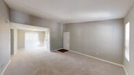 Located on Gears Road in Houston, TX, this single-story unit offers a straightforward, functional layout across several well-defined living spaces. The entry opens into a spacious living area finished with neutral-toned carpet and gray walls, creating a calm, understated atmosphere. A front door with brass hardware and a dark wood mat area anchors the entryway, while natural light filters in through slatted blinds.

The main living room is a standout space, featuring a tile-surround fireplace flanked by two windows and topped with a mirror, adding depth and brightness to the room. Carpeting continues throughout the living and bedroom areas, contributing to a cohesive, comfortable feel.

The kitchen is equipped with white cabinetry, granite-style laminate countertops, a white electric range, a black dishwasher, and a double stainless steel sink positioned beneath a large window with outdoor views. Wood-style flooring runs through the kitchen, offering a practical contrast to the carpeted areas.

The bedrooms are generously sized, with neutral walls, carpet flooring, and ceiling fans for added comfort. The bathrooms feature full tub-and-shower combinations with built-in wall shelving and clean white surrounds.
