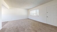 Located at 6141 Orange Ave in Cypress, California, this single-floor, two-bedroom, one-bathroom home offers a practical and well-organized layout. The open living area features neutral-toned carpet and a textured ceiling, with a ceiling fan providing comfort and airflow. Natural light filters in through window blinds, creating a bright and welcoming atmosphere throughout.

The kitchen is a standout feature, showcasing granite countertops, crisp white cabinetry with crown molding detail, and stainless steel appliances including a gas range, microwave, and dishwasher. A peninsula provides additional prep and serving space, while light wood-style flooring and a window overlooking the outdoors complete the functional yet attractive design.

The primary bedroom offers a comfortable amount of space, carpeted flooring, a window with exterior views, and a closet with sliding doors. The second bedroom is similarly appointed with carpet, a window, and clean white walls. A hallway connects the bedrooms to the full bathroom, which includes a tub-shower combination with chrome fixtures. Throughout the home, the consistent use of white walls, neutral carpeting, and clean finishes creates a cohesive, move-in-ready aesthetic suited for easy personalization.