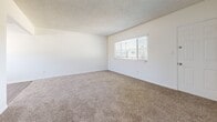 Located at 6141 Orange Ave in Cypress, California, this single-floor, two-bedroom, one-bathroom home offers a practical and well-organized layout. The open living area features neutral-toned carpet and a textured ceiling, with a ceiling fan providing comfort and airflow. Natural light filters in through window blinds, creating a bright and welcoming atmosphere throughout.

The kitchen is a standout feature, showcasing granite countertops, crisp white cabinetry with crown molding detail, and stainless steel appliances including a gas range, microwave, and dishwasher. A peninsula provides additional prep and serving space, while light wood-style flooring and a window overlooking the outdoors complete the functional yet attractive design.

The primary bedroom offers a comfortable amount of space, carpeted flooring, a window with exterior views, and a closet with sliding doors. The second bedroom is similarly appointed with carpet, a window, and clean white walls. A hallway connects the bedrooms to the full bathroom, which includes a tub-shower combination with chrome fixtures. Throughout the home, the consistent use of white walls, neutral carpeting, and clean finishes creates a cohesive, move-in-ready aesthetic suited for easy personalization.