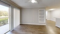 Located at 1545 Kennedy Blvd in Lakeland, Florida, this one-bedroom, one-bathroom residence offers a well-organized single-floor layout designed for comfortable everyday living. The combined kitchen and living room serves as the heart of the home, where wood-style flooring, crown molding, and a ceiling fan create a clean, modern aesthetic. A sliding glass door floods the living area with natural light and offers views of lush greenery outside. A built-in shelving niche adds a functional and decorative touch to the living space.

The kitchen is thoughtfully appointed with gray shaker-style cabinetry, light stone countertops, a subway tile backsplash, a peninsula with an undermount sink, and a full suite of stainless steel appliances including a range, dishwasher, and refrigerator.

The bedroom features plush carpeting, a ceiling fan, and a window that invites natural light. It connects to two closets, including a generously sized walk-in closet outfitted with wire shelving and hanging rods for ample storage.

The bathroom is finished with a clean, white tub-shower combo, wood-style flooring, and neutral-toned walls. A hallway connects the main areas, completing this efficiently designed and well-appointed home.