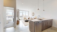 Located at 20 George St in downtown New Haven, CT, this modern 1-bedroom, 1-bathroom residence offers a thoughtfully designed open-concept layout with contemporary finishes throughout. The combined kitchen and living area forms the heart of the home, anchored by a central island with quartz countertops, wood-toned cabinetry, stainless steel appliances, and stylish pendant lighting. Polished concrete flooring runs through the main living space, lending an industrial-chic aesthetic that complements the clean white walls and high ceilings. Large floor-to-ceiling windows flood the living area with abundant natural light and offer open city views. The living room is generously proportioned, providing a comfortable and airy atmosphere. The bedroom features plush carpeting, a built-in closet with shelving, and sliding glass doors that open directly to a private balcony overlooking the cityscape, along with a wall-mounted split HVAC unit for year-round comfort. The bathroom is finished with large-format tile, a frameless sliding glass walk-in shower, and wood-accented vanity cabinetry with a clean quartz countertop. This residence combines modern urban design with functional living in a prime New Haven location.