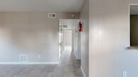 Located at 8917 S Gessner Rd in Houston, TX, this single-story 2-bedroom, 2-bathroom home offers a practical and well-organized layout. Light-toned tile flooring runs throughout the entire space, creating a clean, cohesive look that is easy to maintain. The entry leads into a dining area illuminated by a modest chandelier, with a window that brings in natural light and a direct view of the front door. Adjacent to the dining room, the kitchen features dark cabinetry and connects to a dedicated pantry for additional storage. The living room is a generously sized open area with neutral warm-gray walls and floor vents for climate control. The hallway connects the main living areas to the bedrooms and bathrooms, with ample closet access along the way. The primary bedroom is spaciously appointed, offering two closets and a ceiling fan, while a window provides natural light and exterior views. The second bedroom also features tile flooring and multiple closet doors. Both bathrooms include granite-topped vanities and tile floors. With five total closets spread throughout, storage is a notable strength of this home's design. The overall palette of soft grays and whites lends the space a clean, neutral ambiance throughout.