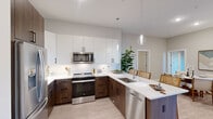 Located at 200 Middletown Blvd in Langhorne, PA, this thoughtfully designed single-floor residence offers 2 bedrooms, 3 bathrooms, a dedicated office, and generous closet space throughout. The open-concept kitchen and living area serves as the heart of the home, featuring two-tone cabinetry with rich walnut lower cabinets and crisp white uppers, a quartz peninsula with bar seating, pendant lighting, a full suite of stainless steel appliances, and light wood-style flooring that extends throughout the main living areas. The bathrooms are finished with neutral tile flooring, wood-toned vanities, and white quartz countertops, maintaining a cohesive modern aesthetic. The primary bedroom is a comfortable retreat bathed in natural light from large windows, complete with carpet flooring and a spacious walk-in closet with built-in wire shelving systems. The second bedroom mirrors the calming palette and soft finishes found throughout. A versatile office space with light hardwood-style flooring provides an ideal area for remote work or creative pursuits. The exterior features a private balcony with black metal railings framed by a striking natural stone facade, offering an attractive outdoor retreat. Neutral gray tones, clean lines, and modern finishes create a cohesive and inviting ambiance throughout the entire residence.