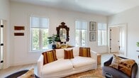 Located at 2601 Montgomery St in Savannah, GA, this thoughtfully designed 2-bedroom, 2-bathroom residence offers a seamless blend of modern finishes and comfortable living across a single floor. The open living room is bathed in natural light from a generous bank of windows overlooking the surrounding greenery, with light wood-tone flooring and crisp white walls creating a bright, airy ambiance throughout. The kitchen is a standout feature, showcasing a large island with a white quartz countertop and bar seating, modern sage-toned cabinetry, stainless steel appliances, and pendant lighting — ideal for cooking and casual dining alike. Both bedrooms are calm and well-proportioned, featuring light hardwood floors, ample closet space with dual-door closets, and warm, neutral tones. The primary bedroom offers a comfortable retreat with dedicated closet access. Each of the two bathrooms is finished to a high standard, featuring floor-to-ceiling tile, glass-enclosed walk-in showers, sleek floating vanities with white countertops, and matte black hardware accents that lend a contemporary edge. Two closets provide practical storage throughout. The overall design is clean and modern, with consistent finishes that give the entire space a cohesive, polished feel.