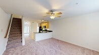 This well-designed home at 9712 Tartuffe Drive, Henrico, Virginia, offers 1000 square feet of living space across two floors. The ground floor (530 sq ft) features an open concept living area with plush carpeting and a modern kitchen. The kitchen boasts honey-colored cabinets, black appliances, and a striking curved island with a sleek black countertop. Track lighting adds a contemporary touch to the space.

Ascending the carpeted staircase leads to the upper floor (470 sq ft), which houses the bedrooms, including the spacious 160 sq ft primary bedroom. All rooms are equipped with ceiling fans for comfort and energy efficiency. Large windows throughout provide ample natural light and views of the surrounding area.

The home's three bathrooms are well-appointed, featuring neutral-toned tile work and white fixtures. The bathtub-shower combinations offer both practicality and comfort. Closet space is available in the bedrooms, ensuring adequate storage.

The property's neutral color palette, combining off-white walls with light carpeting, creates a blank canvas for personalization. This thoughtfully designed home balances functionality with modern aesthetics, making it an ideal space for comfortable living.